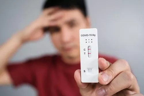 Gestresster Mann mit positivem Covid-19-Test Gestresster Mann mit positivem Covid-19-Test
